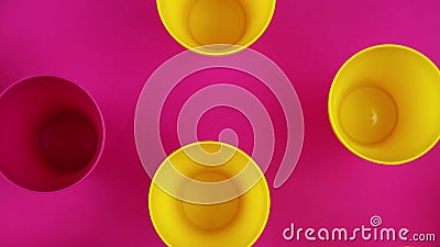 Flat lay top view of a yellow cups with pink background stock video footage